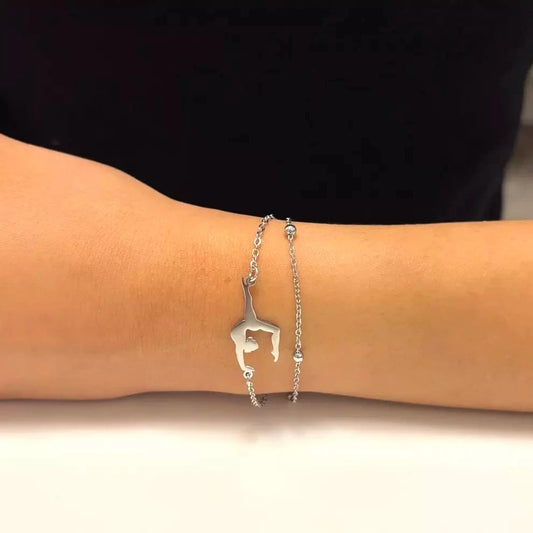 An adjustable stainless steel bracelet with a gymnastics theme, featuring a small gymnastics icon on a person's wrist.