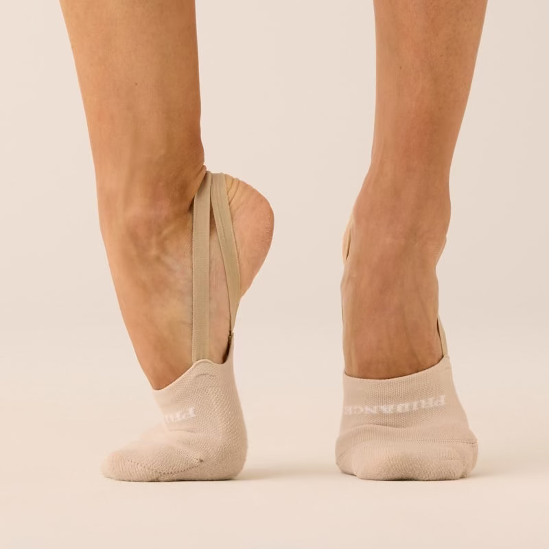 Beige ankle socks worn by a person on a beige background