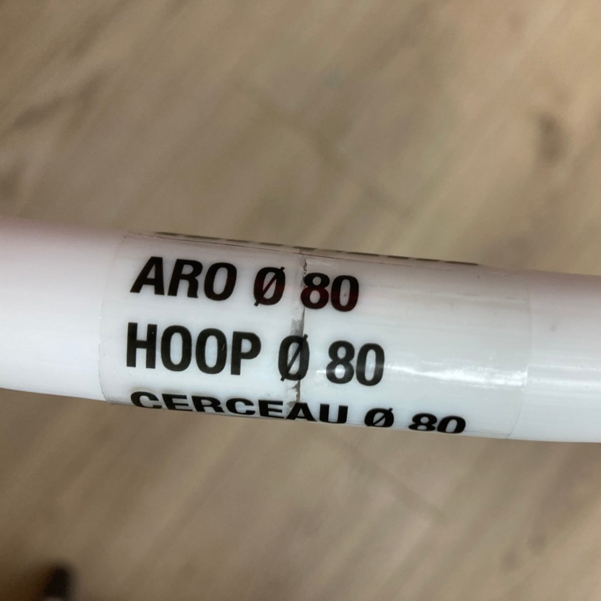 White cylindrical object with black text on a wooden surface