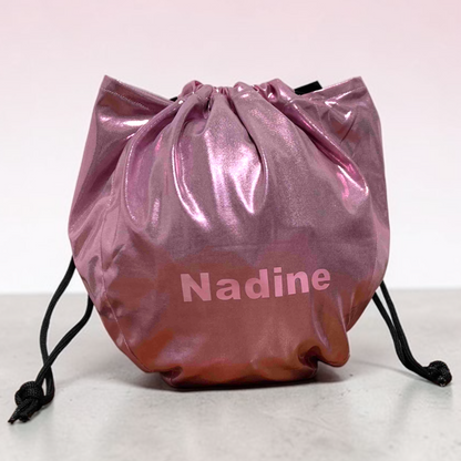 Pink drawstring bag with 'Nadine' printed on it against a white background