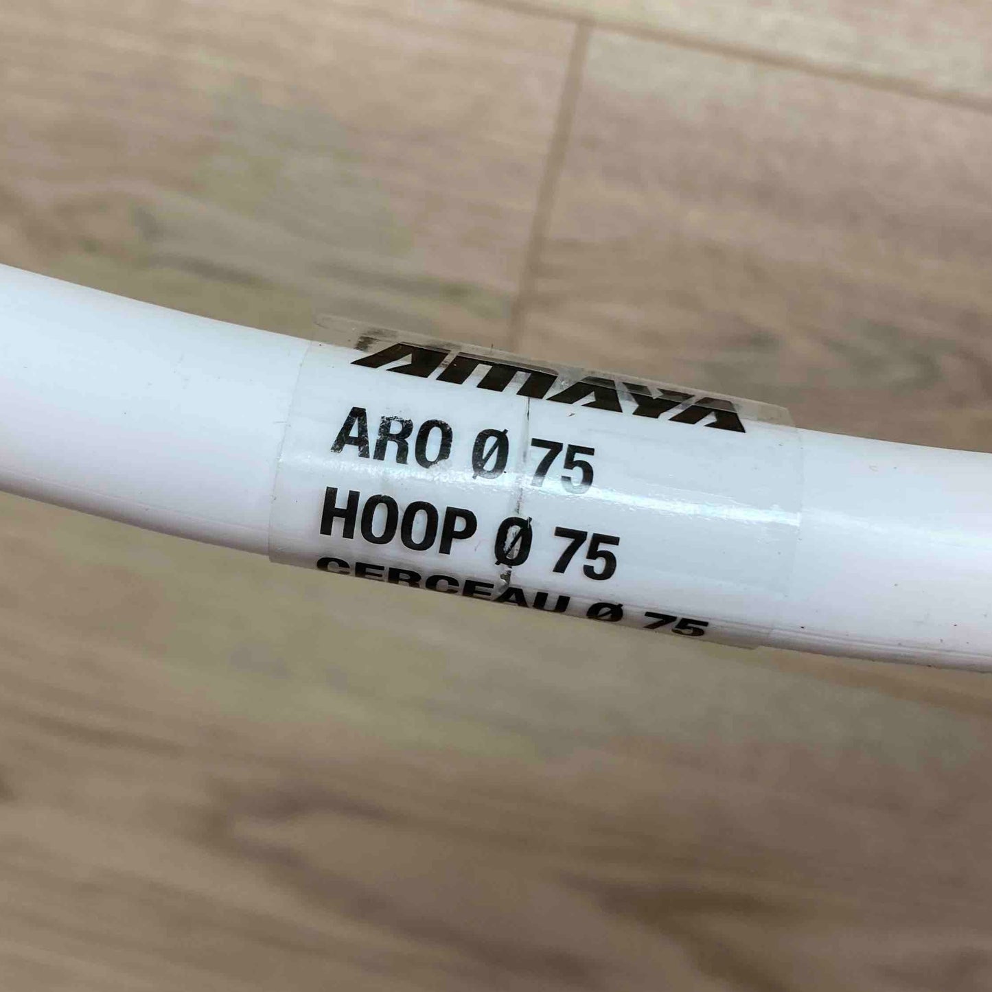 White cylindrical object with black text on a wooden surface