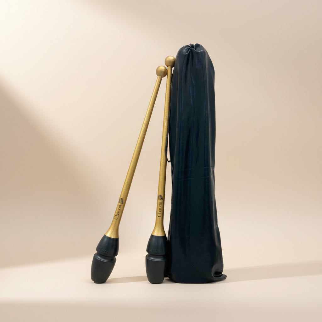 Two clubs with black and gold heads and a black carrying bag on a beige background