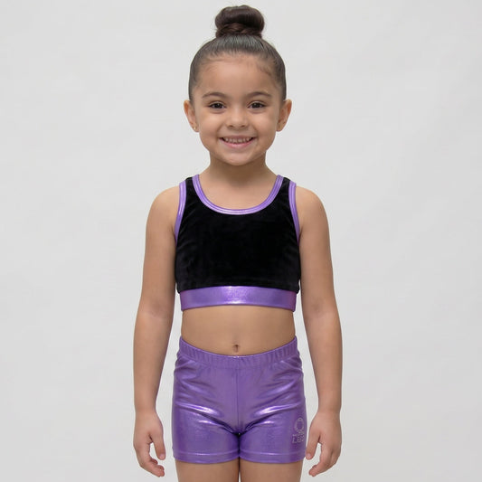 Young girl wearing a black and purple athletic outfit on a white background