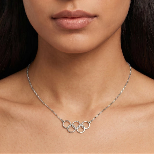 Woman wearing a silver necklace with a plain background